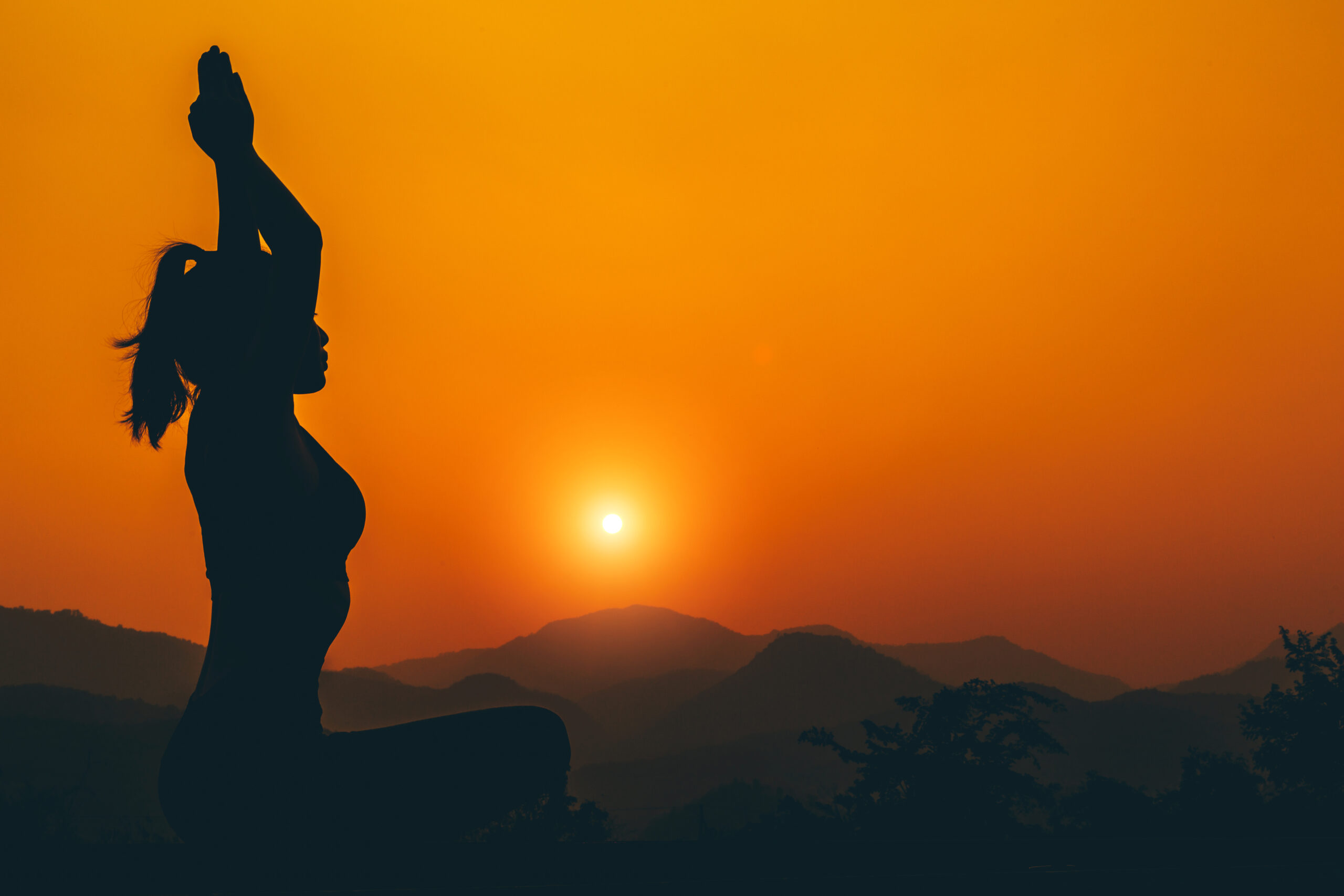 Silhouette - Yoga girl is practicing on the rooftop while sunset